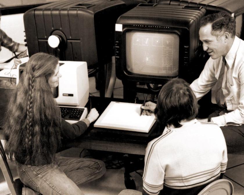 black and white photo of students and male professor working on early computers