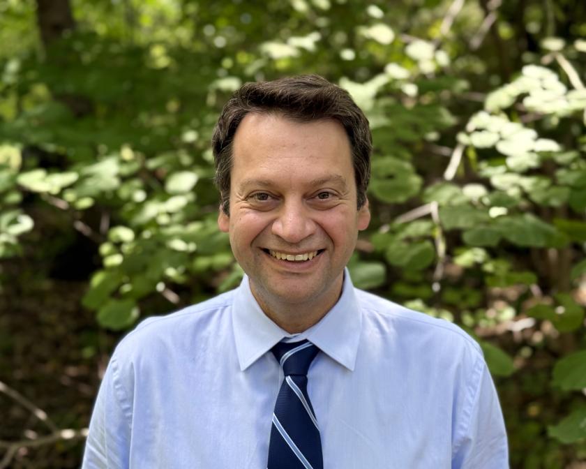 Sorin Lerner smiling at camera in blue shirt and tie