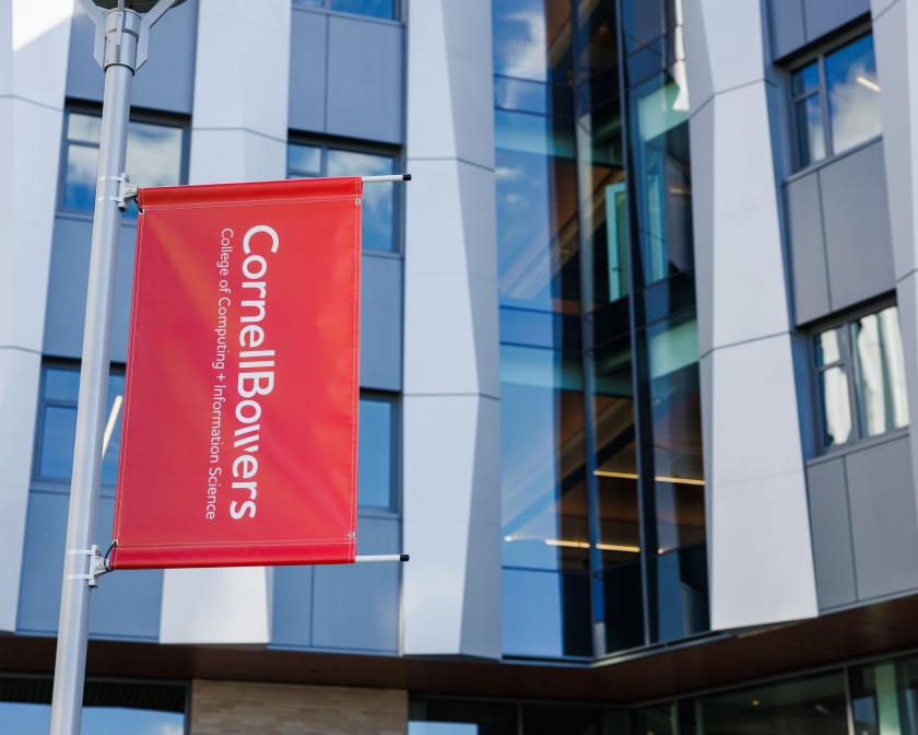 A color photo showing a red banner with the Cornell Bowers logo in white.