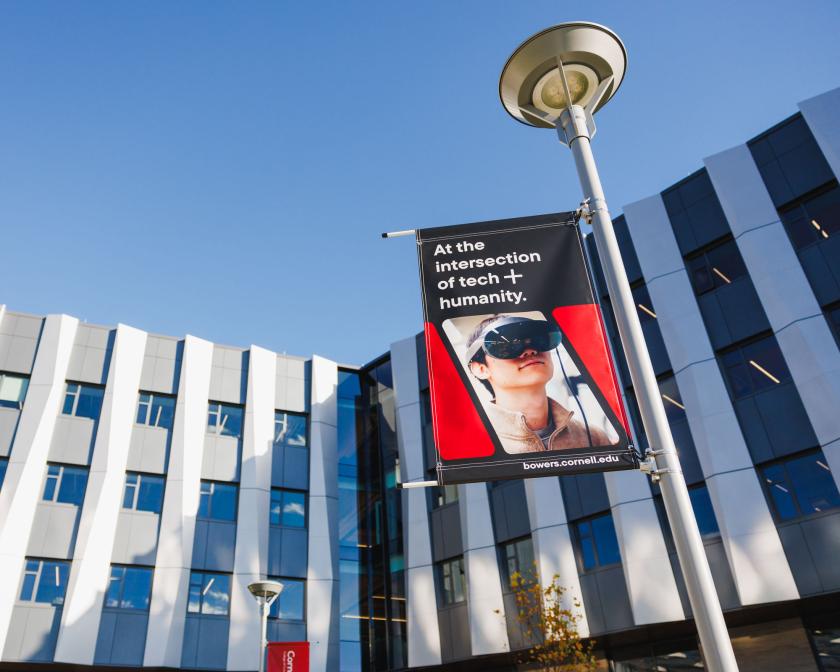 Upward angle of new silver building with black and red flagpole