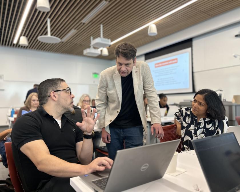 sorin lerner works with two staff members on their laptops