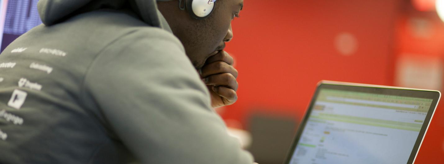 a black male student works on a laptop