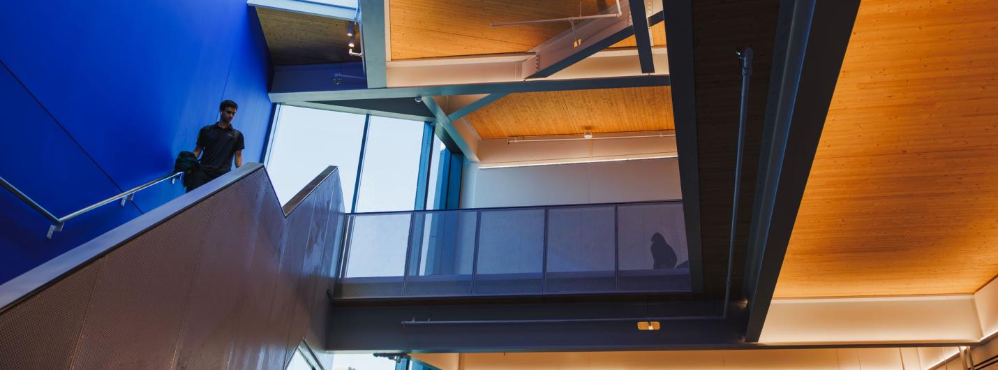 orange and blue angles in the hallways with a person walking down stairs