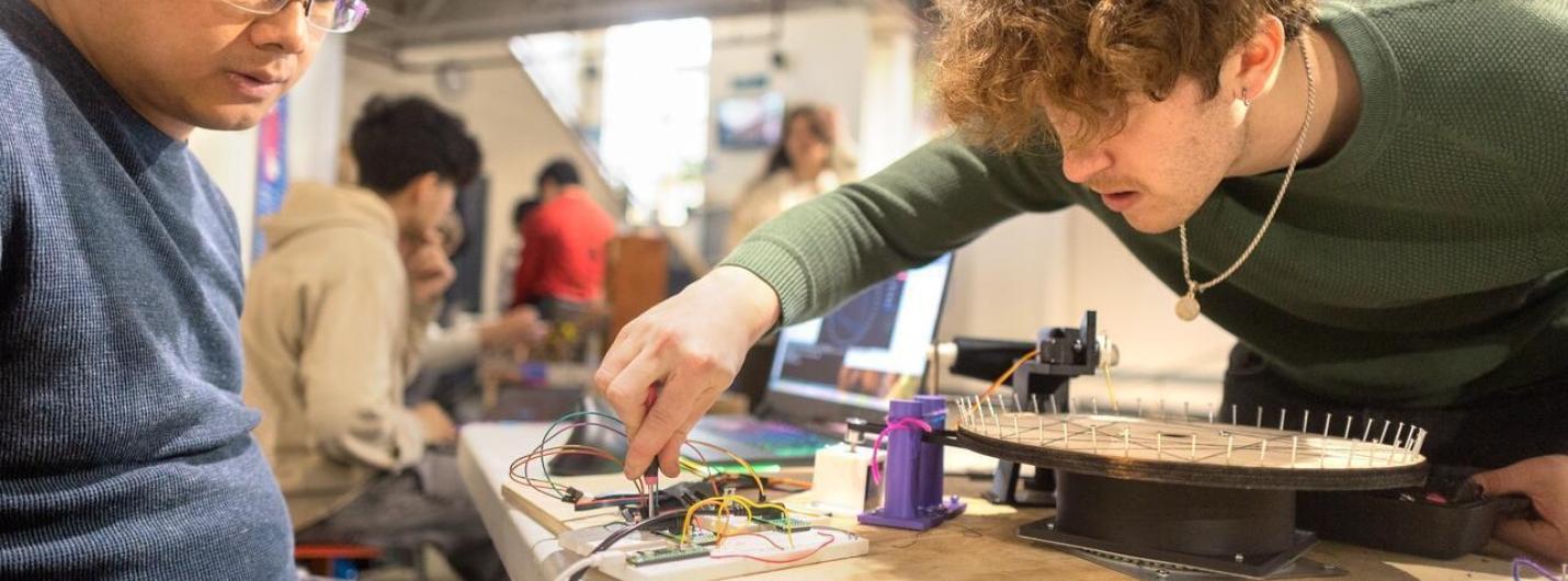 two students work on a hardware device