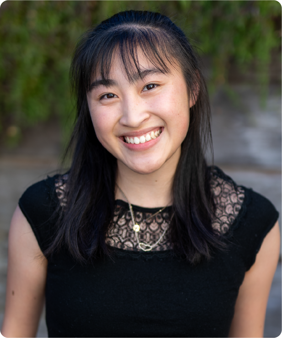 A color photo of a woman smiling for a photo.
